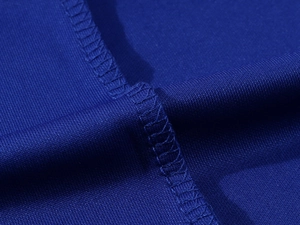 Macro shot of royal blue breathable mesh polo shirt fabric with professional stitching detail