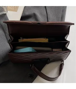 Detailed top view of a brown quilted crossbody bag with multi-compartment interior space
