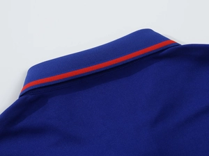 Detail of navy blue piqué polo shirt collar with a vibrant red contrasting stripe
