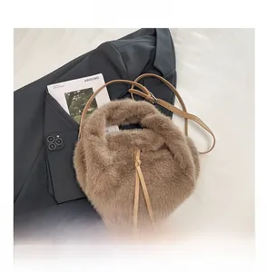 Detail of soft faux fur handbag in camel brown with slim leather shoulder strap and knot