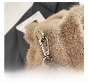 Detail shot of silver metal hook and fluffy brown faux fur on the shoulder bag strap