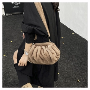 Détail du sac seau en peluche beige avec design plissé et crochets en métal doré
