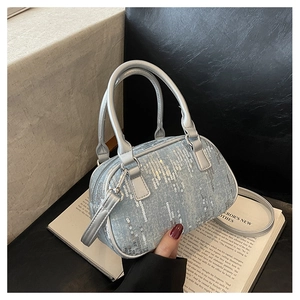 Detail of light blue sequined mini Boston bag featuring silver leather handles and strap