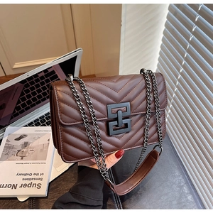 Close-up of deep brown crossbody bag with V-shaped quilting and black metal clasp