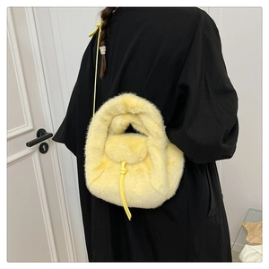Close-up of fluffy yellow faux fur handbag with leather strap on a model back