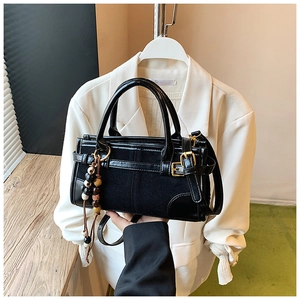 Dettaglio della borsa baguette nera in pelle PU con cuciture in pelle scamosciata e perline