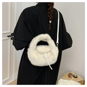 Close-up of white faux fur handbag with leather strap and decorative bow detail