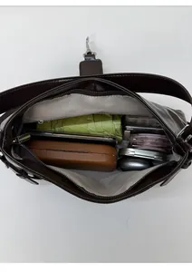 Macro interior view of dark brown leather bag showing spacious capacity and daily items