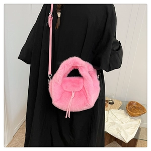 Detail view of pink faux fur handbag with adjustable leather strap and fluffy texture