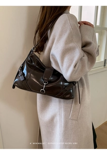 Chic dark brown glazed leather baguette bag with retro metal buckle shown on shoulder