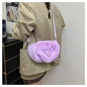 Close-up of light purple faux fur crossbody bag featuring smooth leather shoulder strap