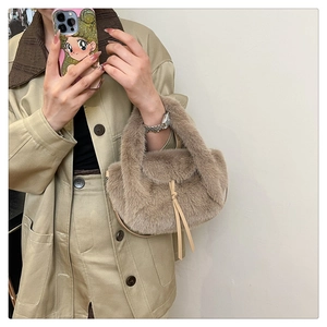 Detail of light brown plush handbag showing soft faux fur texture and leather drawstring