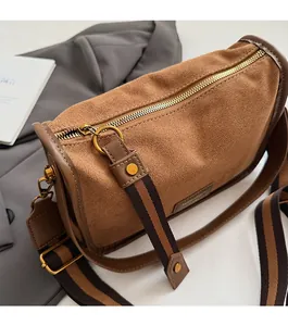 Detailed macro of brown suede Boston bag featuring vintage gold zipper and wide strap