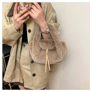 Detail of soft faux fur texture on a khaki plush handbag with leather drawstring strap