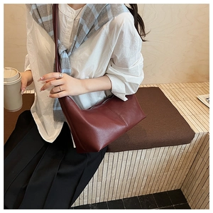 Macro detail of wine red hobo bag showing matte faux leather texture and elegant stitching