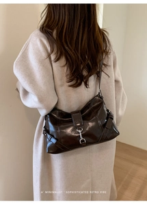 Retro coffee brown glossy leather crossbody bag with metallic buckle detail on strap
