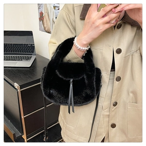 Detailed texture of black faux fur tote bag with leather strap and metal hardware