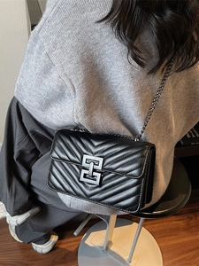 Quilted black leather crossbody bag with chain strap shown on model for size and fit
