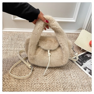 Detail of plush faux fur handbag in beige with soft texture and leather strap