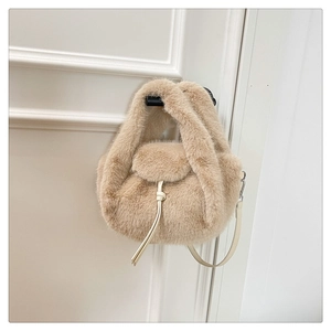 Detail view of plush faux fur handbag with drawstring knot and thin leather strap