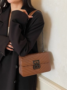 Brown quilted crossbody bag with V-shaped stitching and black metal chain strap