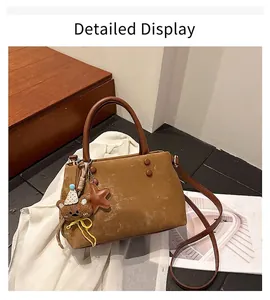 Borsa a secchiello in camoscio marrone con ciondolo a forma di orso e tracolla regolabile