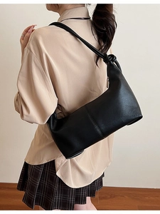 Minimalist black matte faux leather hobo bag with a decorative knotted shoulder strap