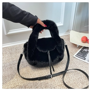Close-up of black faux fur plush handbag showing soft texture and leather drawstring detail