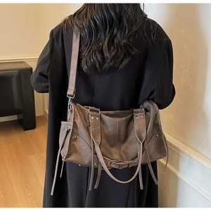 Détail d'un sac cabas vintage marron avec de longues franges et des boucles métalliques