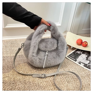 Detail of grey plush faux fur handbag with soft texture and adjustable leather strap