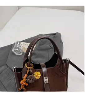 Detail of dark brown bucket bag featuring leather suede patchwork and silver hardware