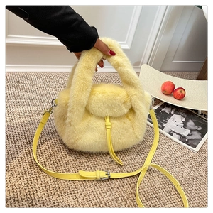 Detail of light yellow faux fur handbag featuring drawstring closure and leather strap