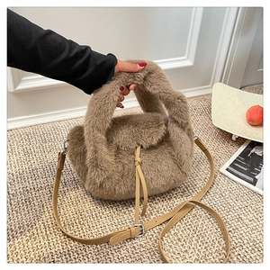 Detail of light brown faux fur handbag with leather handle and adjustable silver buckle