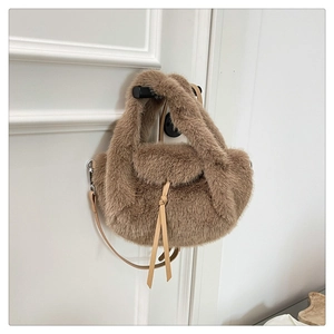 Detail of soft brown faux fur texture and leather strap on a plush shoulder bag