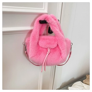 Detail of pink plush crossbody bag featuring soft faux fur texture and leather tassels