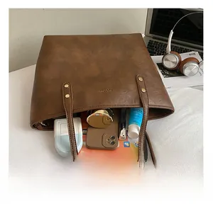 Brown tote bag interior showing large capacity for laptop, phone and cosmetics