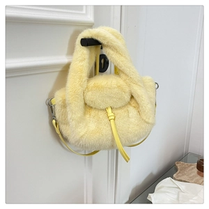 Pale yellow faux fur handbag detail showing soft texture and strap on a white door