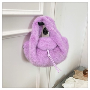 Detail of lavender purple faux fur handbag texture hanging on a white door handle