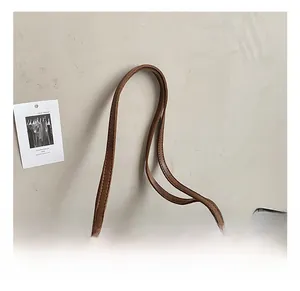 Detail of comfortable brown leather tote bag handle with vintage copper rivets
