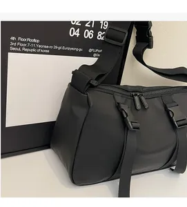 Detail of black nylon tactical crossbody bag showing zippers and adjustable shoulder strap