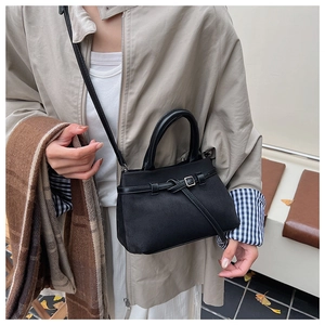 Detail of black crossbody bag with matte finish, silver buckle, and slim shoulder strap