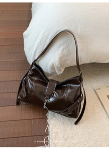 Detail of vintage dark brown faux leather shoulder bag with metallic buckle detail