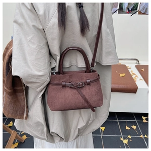 Detail of vintage matte brown bucket bag with leather strap on an autumn background