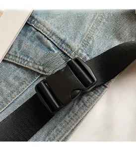 Close-up of durable black buckle and nylon strap on wash blue denim crossbody bag