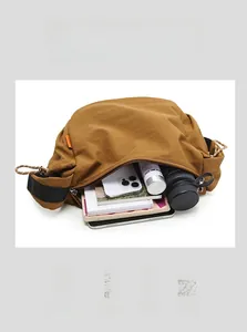 Vista dettagliata della grande borsa a tracolla in nylon marrone con interno ampio e capiente