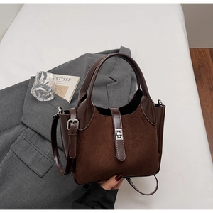 Detailed top view of a brown suede bucket bag featuring a silver twist lock and strap