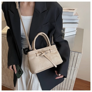 Detailed texture of beige frosted suede bucket bag with leather strap and metal buckle