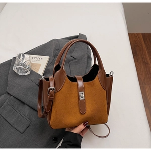 Detail of vintage matte bucket bag featuring leather patchwork and silver metal buckle