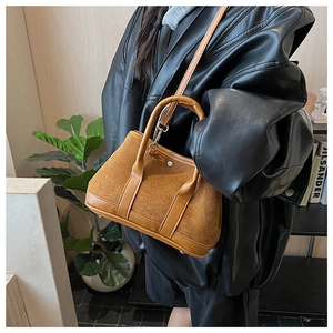 Detail of vintage brown suede tote bag showing premium mixed textures and silver hardware