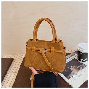 Detail of brown frosted leather bucket bag with silver metal buckles and retro texture